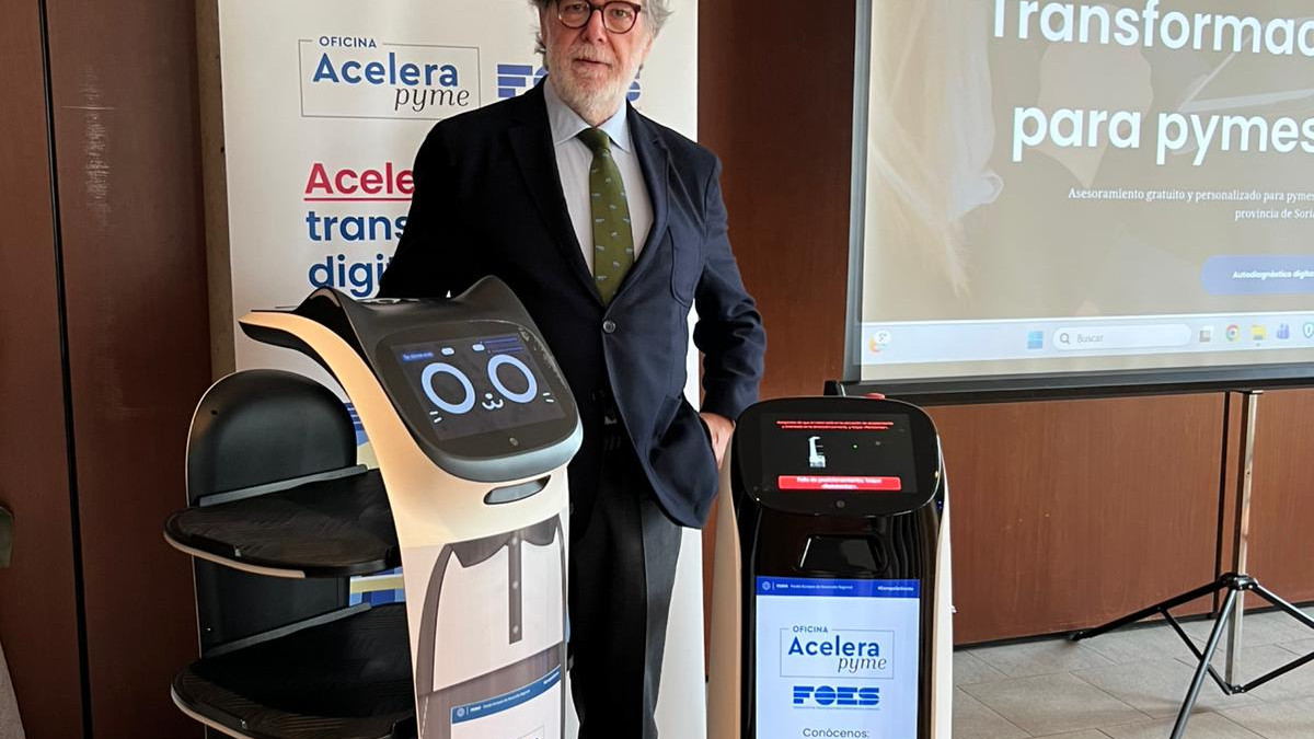 Imagen: Santiago Aparicio, presidente de FOES, junto al robot encargado de servir cafés al inicio de la jornada a todos los asistentes.   