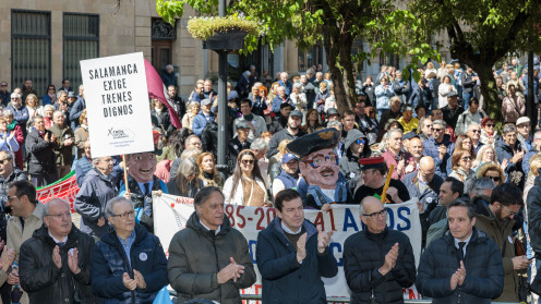 Fotografía de la concentración ciudadana bajo la lluvia en la Plaza de los Bandos de Salamanca con pancartas a favor del tren