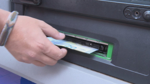Un cliente retira dinero en efectivo de un cajero automático
