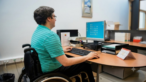 Fotografía de recurso (ASPAYM) que muestra a jóvenes profesionales en un entorno de trabajo inclusivo y accesible en Castilla y León.