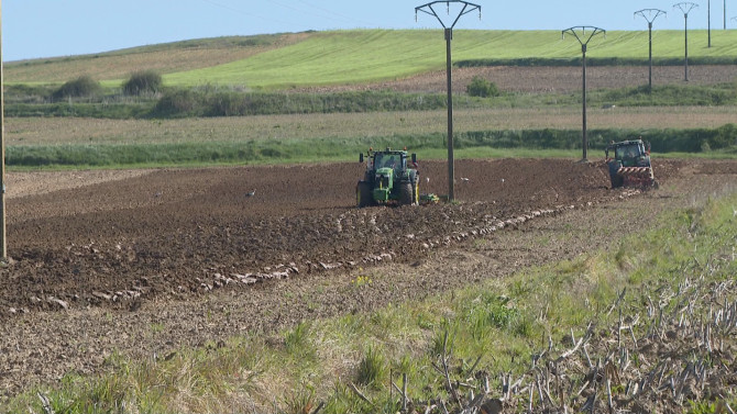 Dos vehículos agrícolas realizando trabajos en el campo
