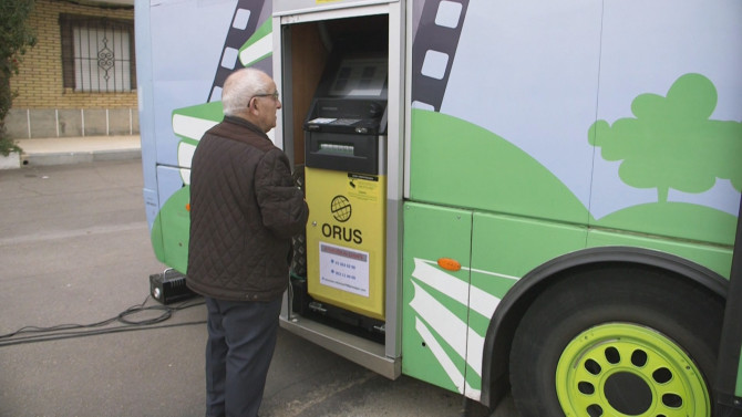Un cliente usando uno de los cajeros automáticos incorporados en los bibliobuses que recorren la provincia de Salamanca